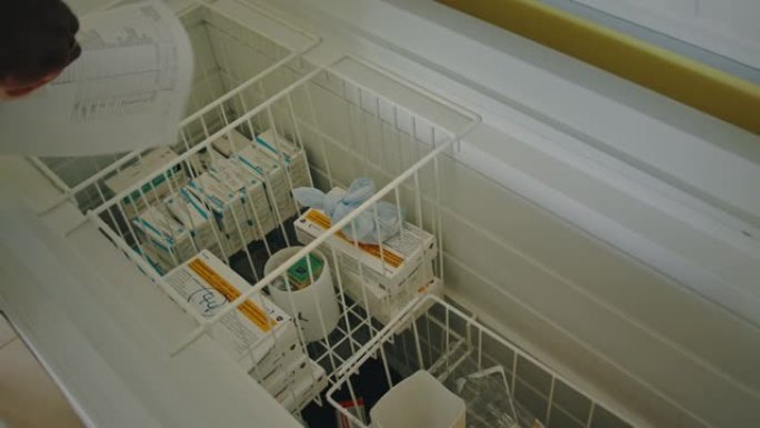 当地乡村医疗护士医生在乡村医院诊所的冷冻冰箱中工作并选择疫苗接种