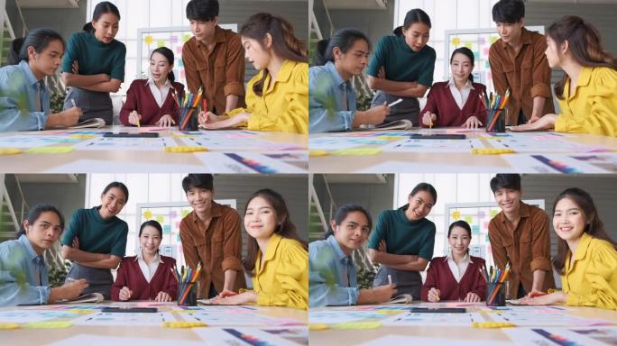 亚洲女性领导者建议ux/ui设计师关于移动应用界面线框设计在桌子上并在现代办公室抬头看相机。创意数字