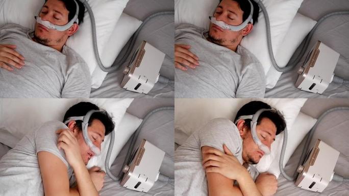 oung成年男子戴着鼻面罩 (CPAP面罩) 并使用CPAP机睡觉