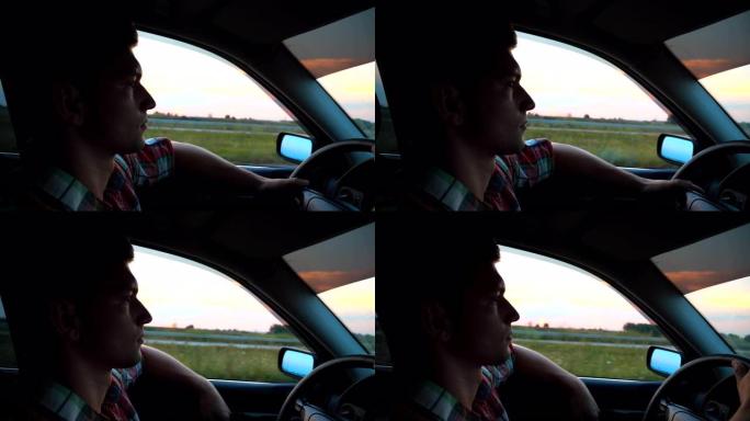 穿衬衫的帅哥驾驶汽车穿越乡村。年轻人把手从窗外骑着汽车，享受公路旅行。背景下美丽的夜景。慢动作特写