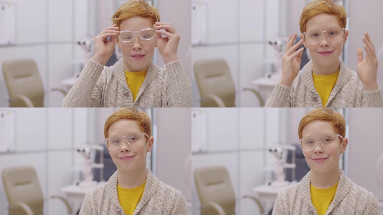 戴着眼镜的快乐红发男孩在眼科诊所为相机摆姿势