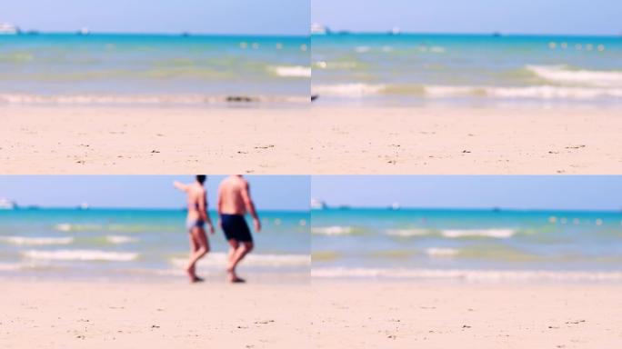 4K UHD假日概念。局部海滩有海浪从海上来到海滩，有人类步行通道。软聚焦和对沙子有选择性的聚焦。