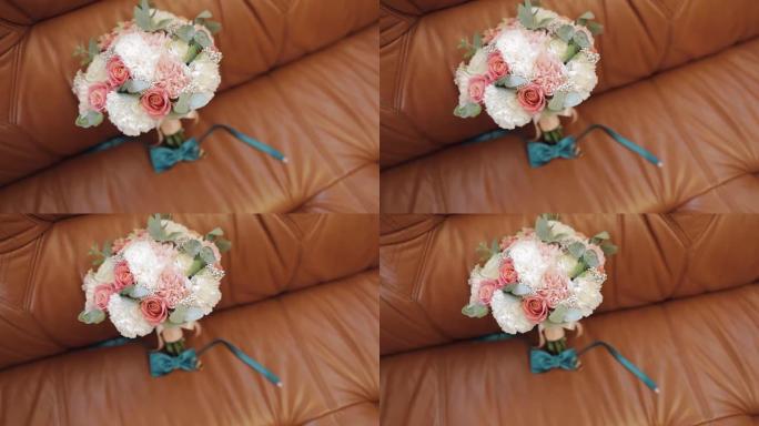美丽的婚礼花束躺在沙发上，配有结婚戒指和新郎领结