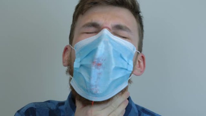 戴着医用口罩的被感染的年轻人正在咳血。结核病流行。大流行保护新型冠状病毒肺炎冠状病毒。病毒保护