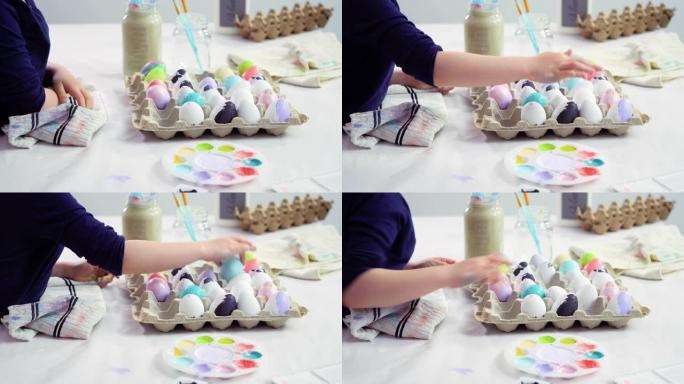 小女孩用丙烯酸涂料绘画工艺复活节彩蛋。