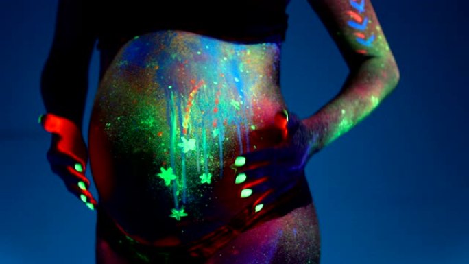 在紫外线下涂上荧光化妆品的孕妇身体部位