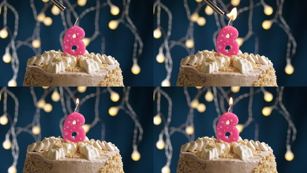 蓝色背景上有6个数字粉色蜡烛的生日蛋糕。蜡烛着火了。慢动作和特写视图
