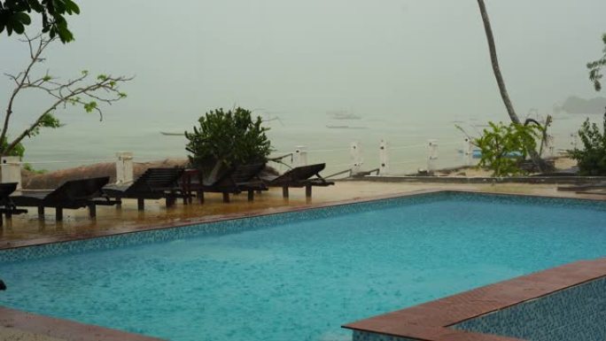 热带夏季雨水落在海上游泳池上