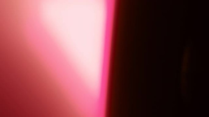 黑色背景上有粉红色的光线泄漏。叠加。照片过滤器。过渡