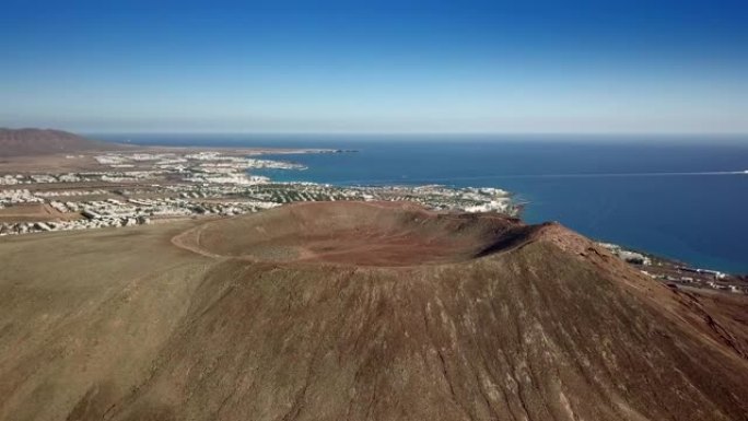 火山火山口市中心前面的红山兰萨罗特岛的白色海滩