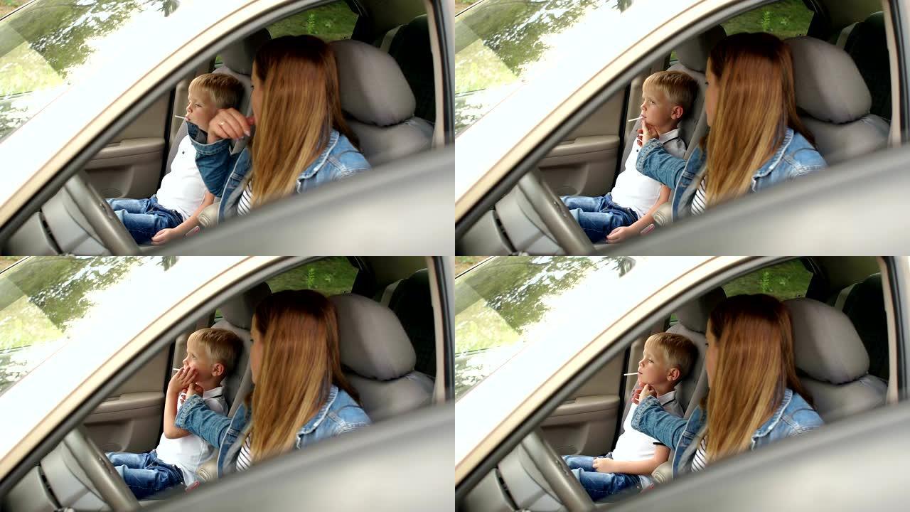 一个女人的肖像，一个孩子在汽车前排座位上，孩子吃糖果。