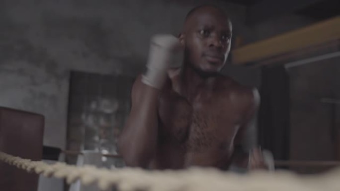 年轻的黑人拳击手在搏击俱乐部独自接受裸露的躯干训练