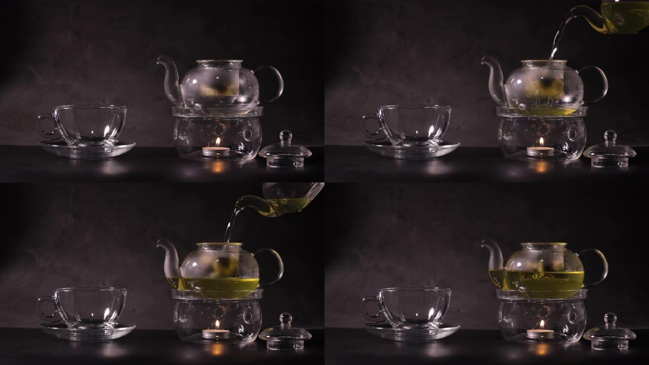 倒入热水将绿茶倒入厨房的茶壶中。经典茶壶由玻璃和蜡烛烧开水制成。热饮和茶时间概念