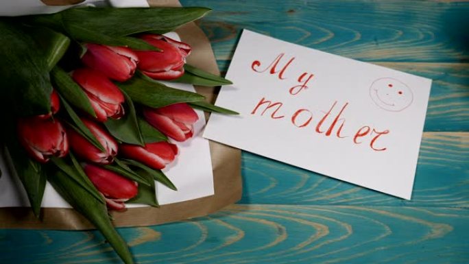 我母亲的留言便笺和木桌上的郁金香花束的俯视图。爱情关系概念。母亲节。4 k拍摄