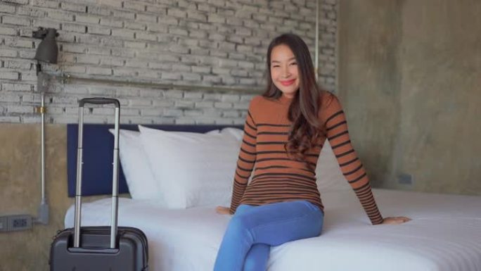 年轻的亚洲女性快乐的微笑在卧室的床上放松