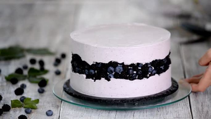 厨房里的糖果店用浆果奶油做海绵蛋糕。自制糕点的概念，烹饪蛋糕。