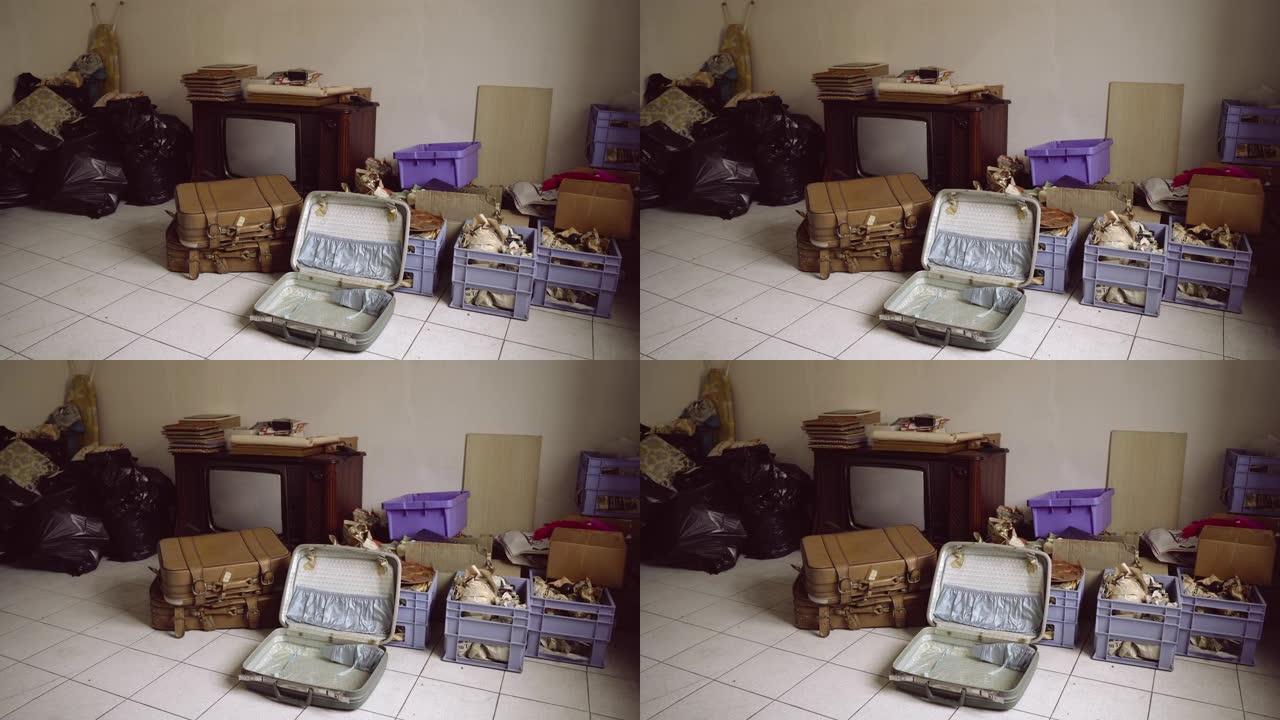 旧的复古电视和一堆用过的不必要的东西在战时疏散建筑的空废弃房间里。过去的回声，包裹着垃圾场，古董和生