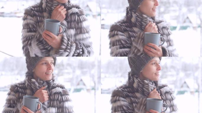 穿着皮大衣和针织毛线帽的快乐美丽女孩在一个寒冷的冬天早晨从杯子里喝咖啡。一名年轻女子在街上喝茶，下雪
