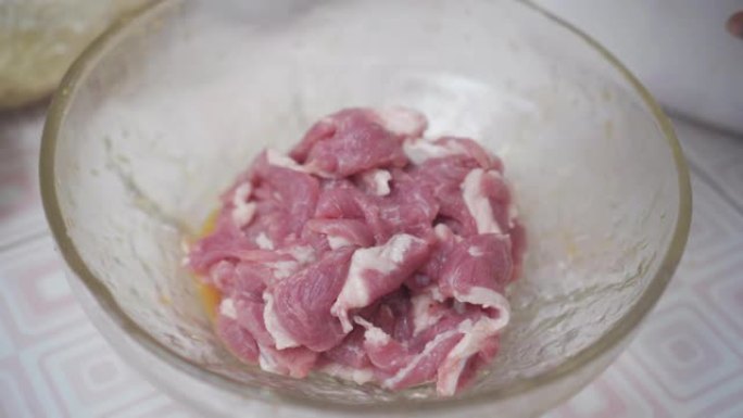 在碗里用酱汁腌制猪肉。泰国菜。