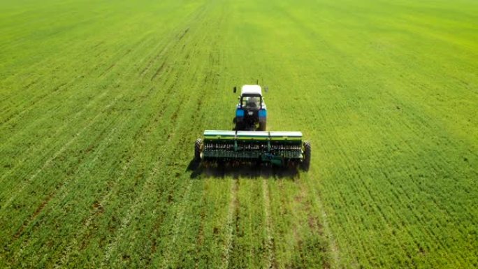 无人机在田间的拖拉机上射击农民，为农作物施肥以提高生产力