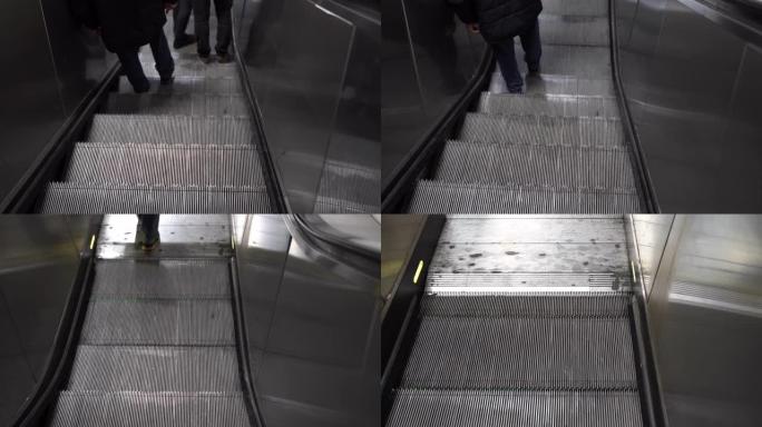 人们的腿从地下地铁站的自动扶梯上爬下来。火车站或大型购物中心的现代快速运输方式。自动扶梯概念