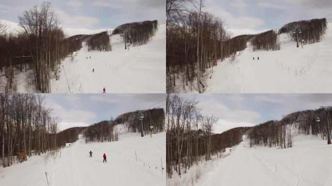 滑雪者和滑雪者乘坐滑雪缆车，而人们则在冬季滑雪胜地的背景中滑雪。