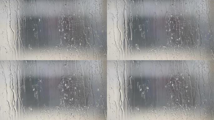 雨滴在窗户玻璃表面，建筑背景模糊，4k电影，b卷镜头。