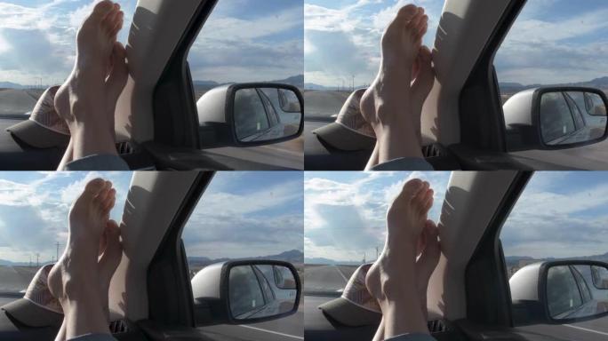 公路旅行脚在仪表板上欣赏侧镜中的风景反射