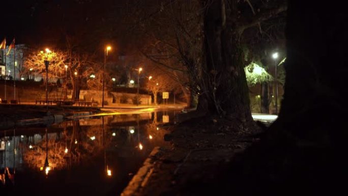 秋夜城市街道雨后路灯倒映雨水坑