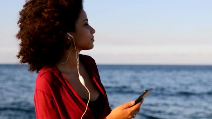 拉丁美洲妇女在海边听音乐