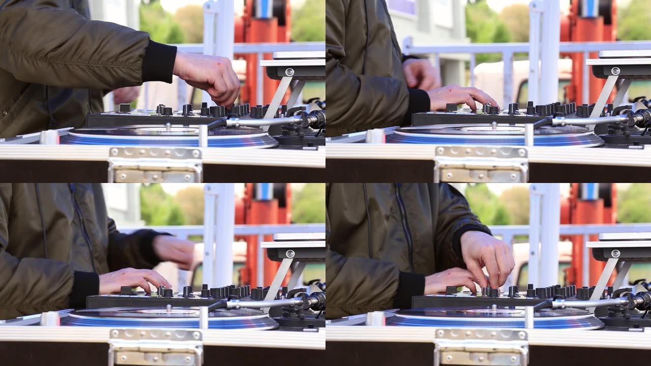 DJ播放音乐，在露天派对上在转盘上刮擦黑胶唱片。双手特写。