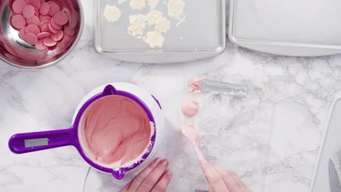 Pouring melted chocolate into a plastic chocolate 