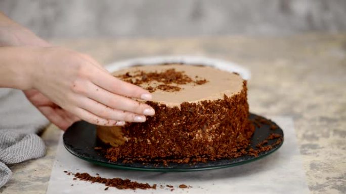 在巧克力蛋糕上撒上面包屑。用面包屑覆盖拿破仑蛋糕。烹饪的过程，食谱甜点。