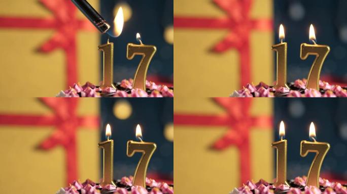 生日蛋糕编号17点灯燃烧的金色蜡烛，蓝色背景礼物黄色盒子用红丝带绑起来。特写和慢动作