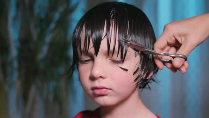 一个孩子的特写，理发师甚至在他的头上剪了一条直线的头发