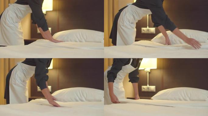 女佣在酒店房间铺床铺毯子