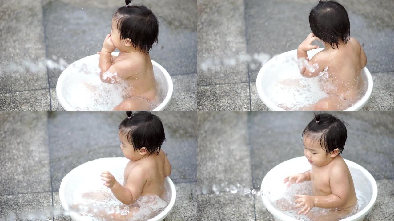 亚洲婴儿淋浴在白色浴缸和家庭户外嬉戏