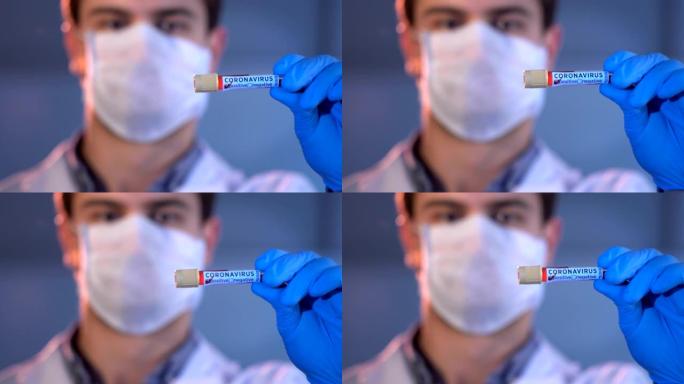 实验室研究人员持有冠状病毒 “阳性” 标记的血液试管