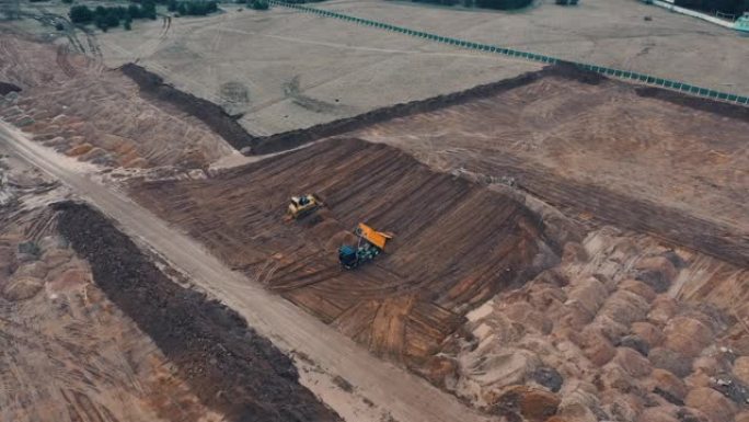 从顶部无人机看履带式挖掘机控制操作员推土机挖掘沙石在公寓楼建设城市睡眠区现场公寓高层建筑的准备