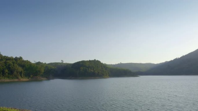 从湖上有绿色海岸和山丘的山丘或水坝上的景色