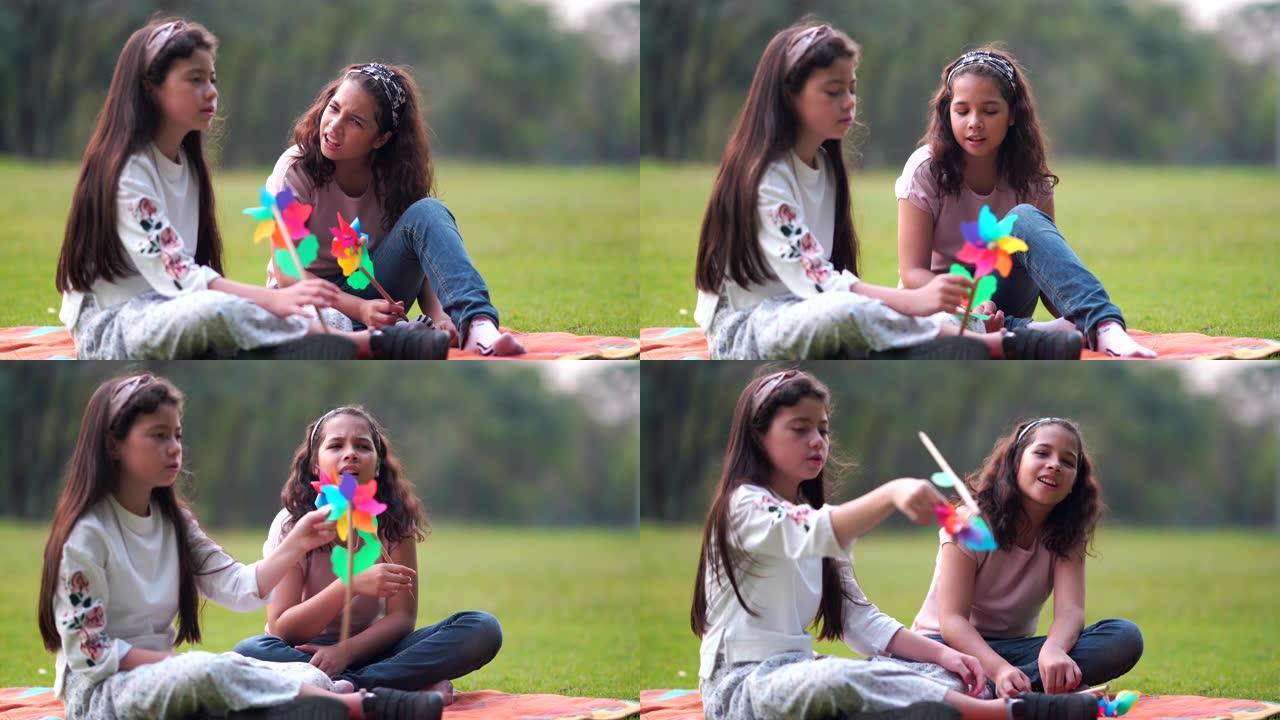 两个漂亮的年轻女孩和朋友在公园玩涡轮机阳光明媚的秋天在公园里，在公园里说笑