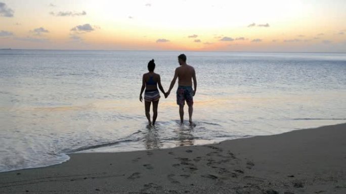 圣卢西亚海滩，男女中年夫妇在圣卢西亚加勒比海度假期间在海滩上散步