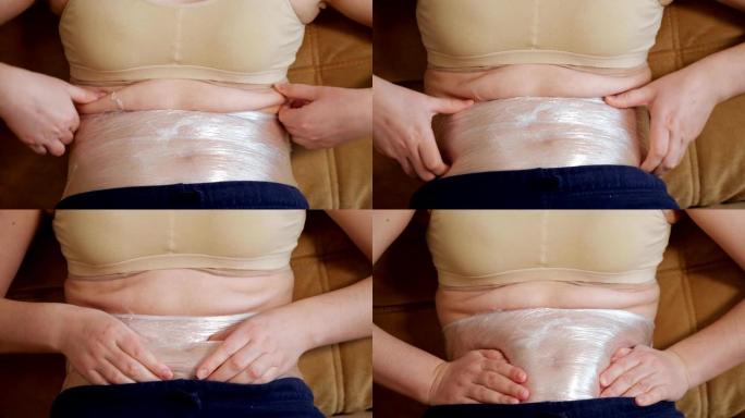 女人的腹部特写，用保鲜膜包裹
