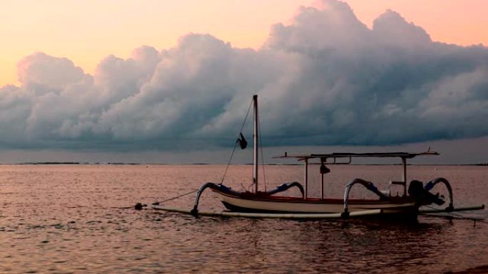 巴厘岛的一艘支腿渔船在日出时平静地漂浮着