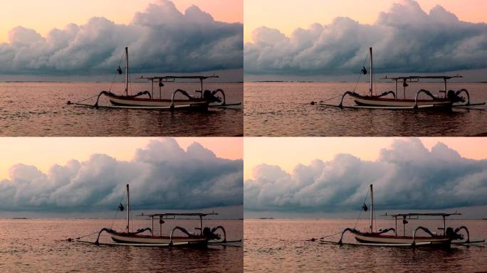 巴厘岛的一艘支腿渔船在日出时平静地漂浮着