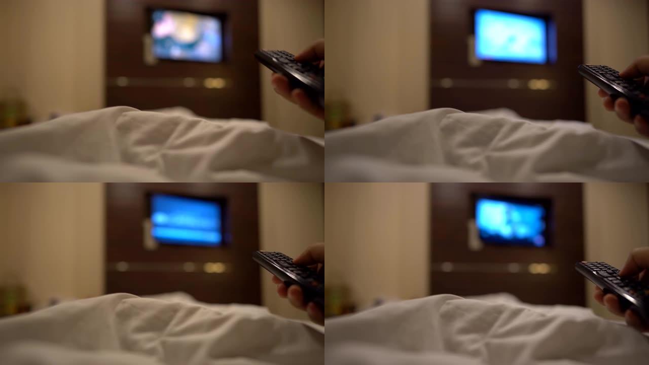 近距离手持遥控器，选择香奈儿，晚上在卧室的床上看电视