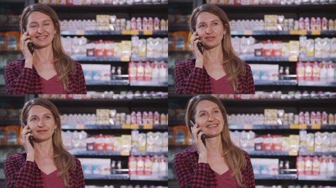 站在超市内部的快乐美国女人通话的前视图