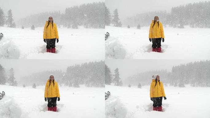 冬季旅行者。一位年轻女性游客的慢动作，在深雪中享受外面的降雪。在冬天的山上玩得开心。肖像。