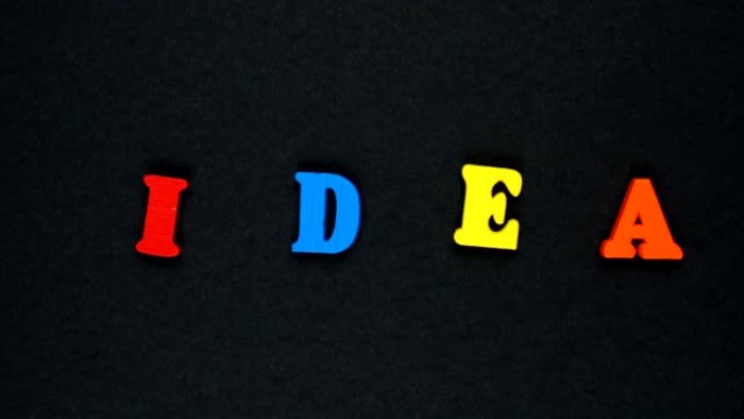 由木制五彩字母组成的单词 “IDEA”。五颜六色的单词循环。