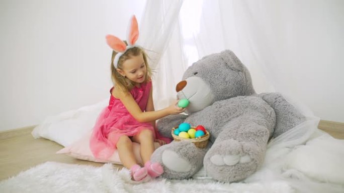 小女孩喂大玩具熊复活节彩蛋